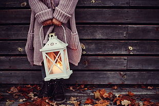 person holding white candle lantern