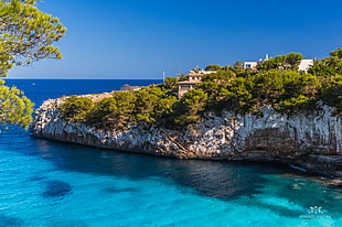 aerial view of house on top of a mountain that is covered with blue sea under the blue sky during daytime, mallorca