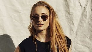 woman in black sleeveless top with black sunglasses