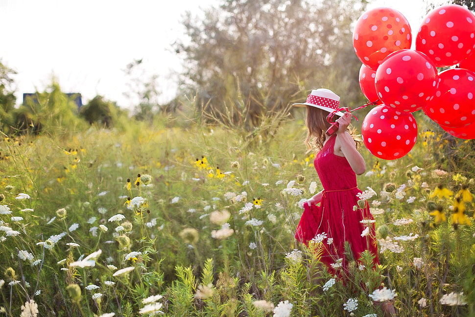 photo of woman holding red balloons in the flower plants HD wallpaper