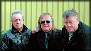 three men's wearing black coats
