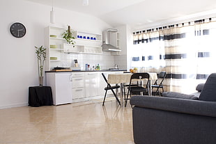 white wooden kitchen table in front of glass-top dining table and chairs