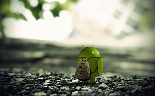 selective photo of android with backpack standing on gravels