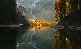 landscape photography of body of water surrounded by trees near mountain