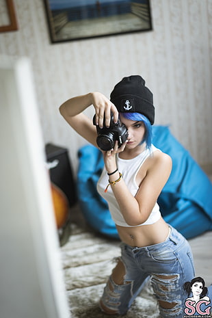 woman wearing black beanie cap and white crew-neck tank-strap crop-top holding black DSLR camera HD wallpaper