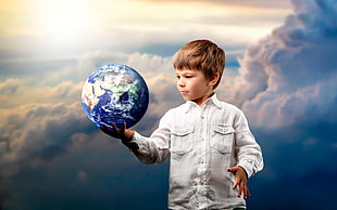 boy holding the Earth scale model at the white clouds