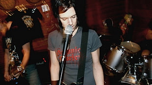 person in gray crew-neck t-shirt near microphone