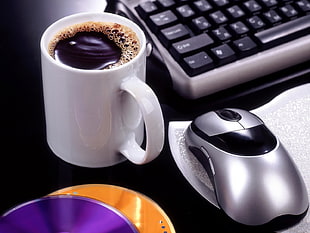 white ceramic mug near computer keyboard beside mouse