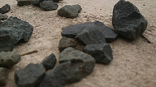 black and gray stone fragment, stones, sand