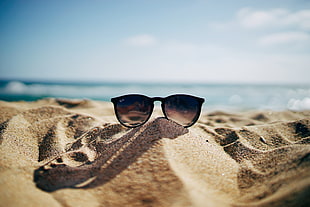 photo of a brown framed Ray-Ban wayfarer sunglasses on brown sands