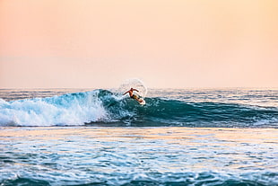 man surfing on body of water during daytime