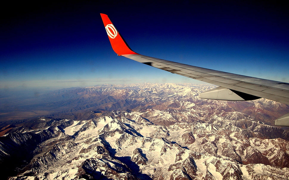 red and gray airliner flying during daytime HD wallpaper