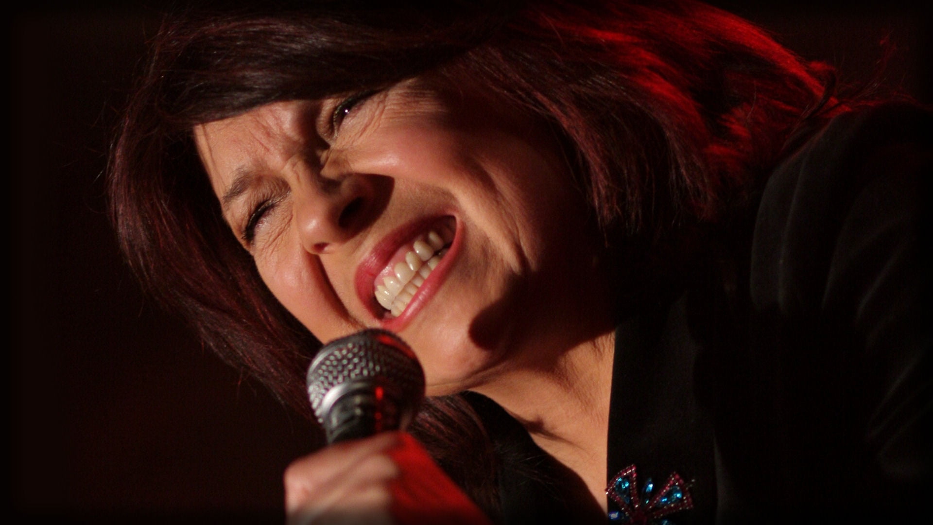 woman in black dress holding microphone