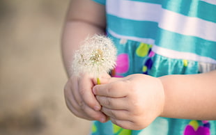 girl holding dandelion