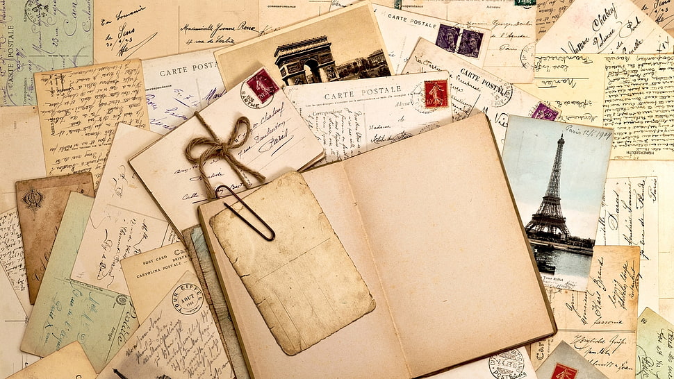 journal surrounded by postcards HD wallpaper