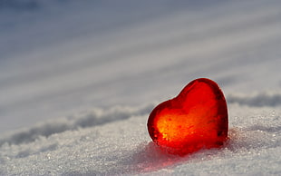 heart-shaped red stone in snow