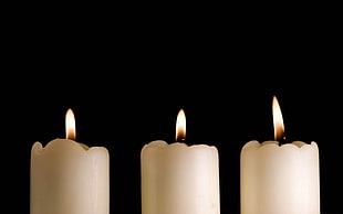 three white lighted candles