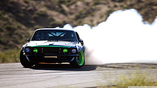 black and green car drifting on sand