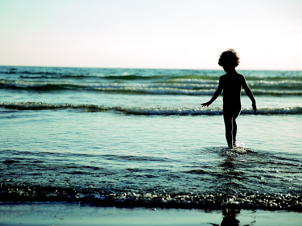 silhouette photography of child on seashore under blue sky HD wallpaper