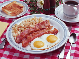 bacon with fried eggs on white ceramic plate