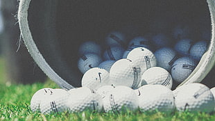depth of field photography of white golf balls inside container