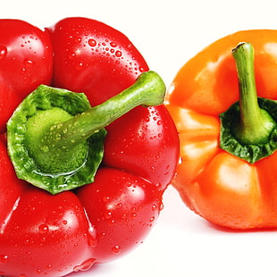 close-up photo of two red and orange bell peppers