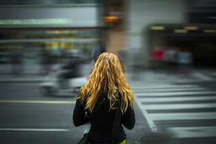 woman in black long sleeve shirt watching  people on street during daytime