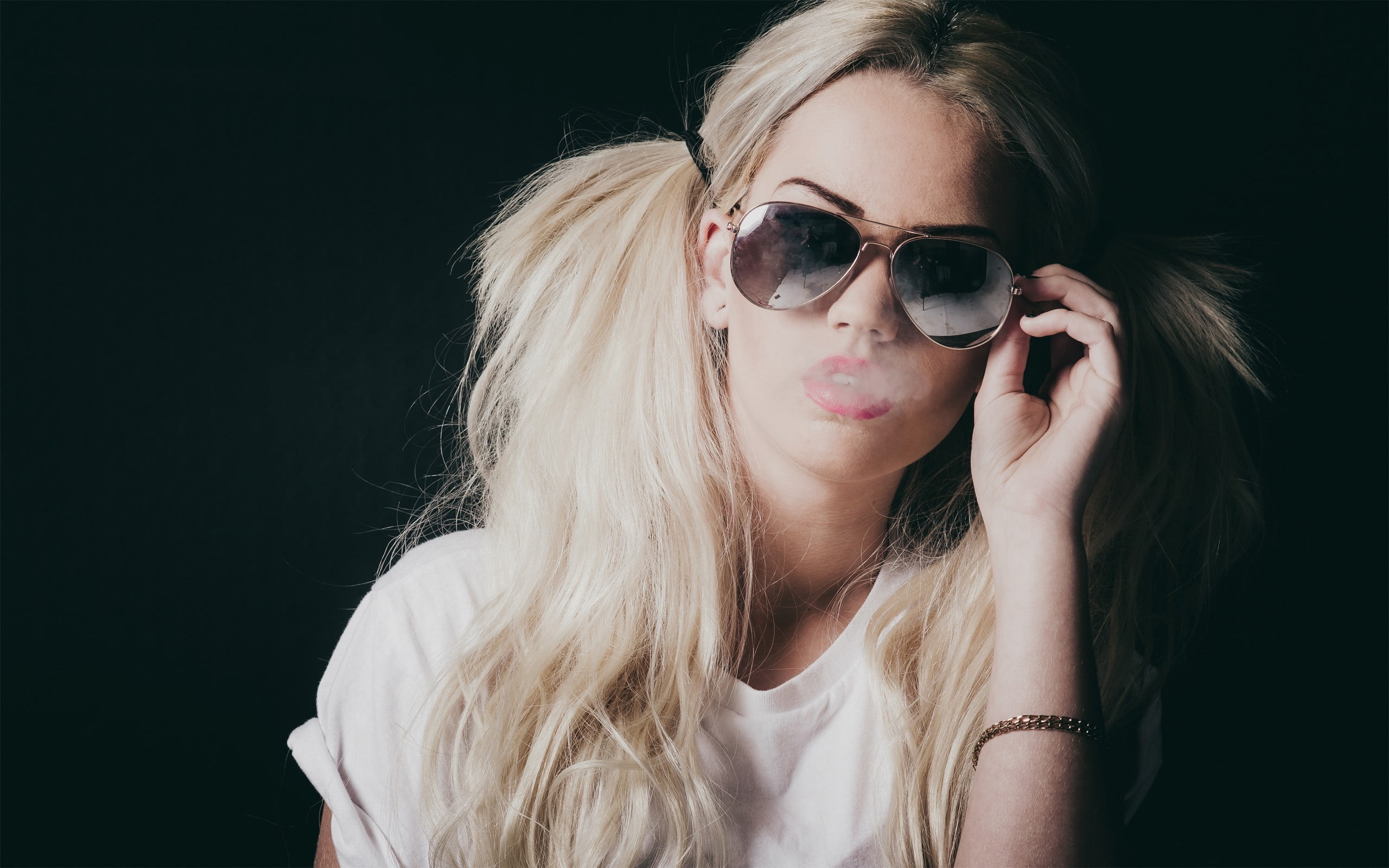 woman in white shirt holding sunglasses