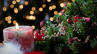 lighted candle beside Christmas wreath