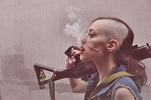 woman holding rifle while smoking cigar