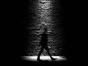 silhouette photo of person near wall