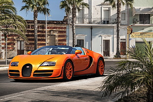 photo of orange super car near white concrete building