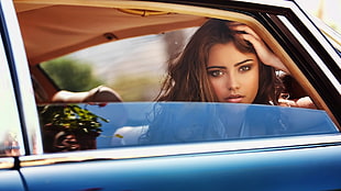 woman sitting inside blue car during daytime