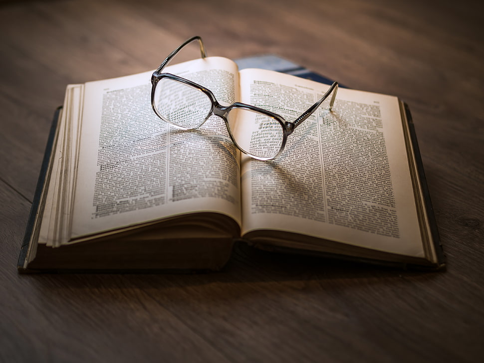 black-framed eyeglasses on top opened book HD wallpaper