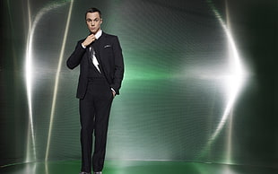 man in black formal suit with green background