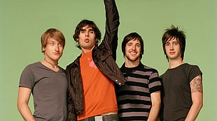four men standing beside each other on green screen