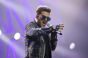 man wearing black studded leather jacket and gray wireless microphone