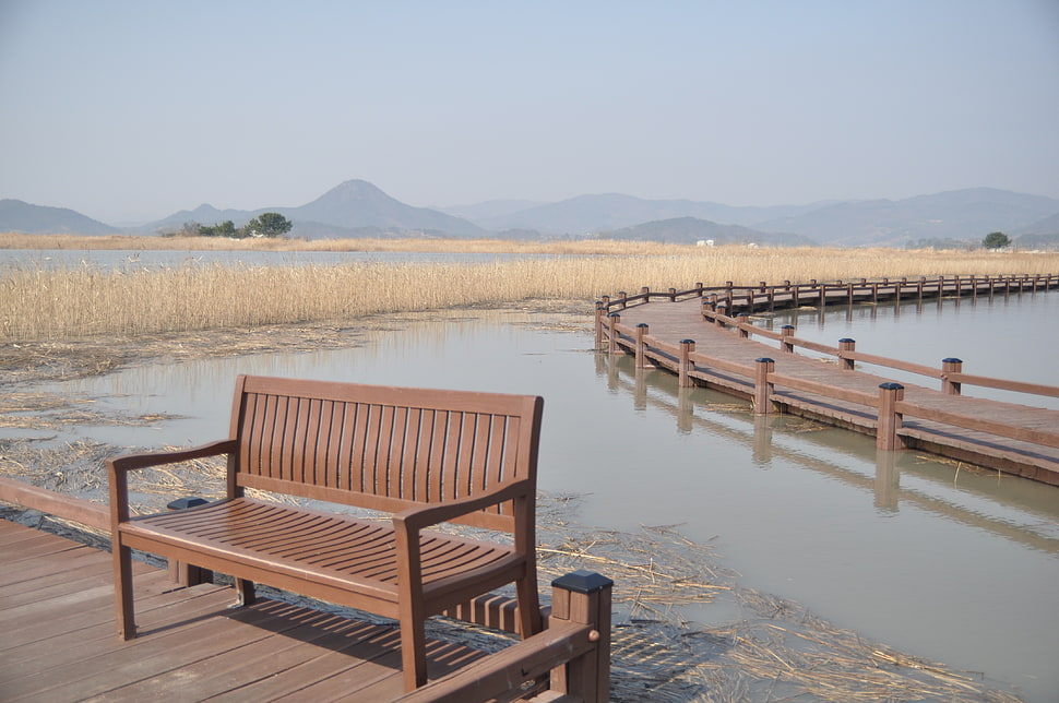 brown wooden bench near pathway bridge HD wallpaper