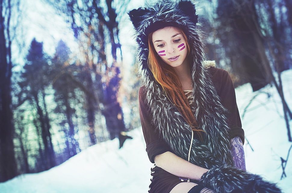 woman with wolf costume sitting in the snow HD wallpaper