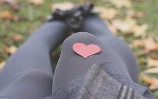 red heart shape decor on persons black stockings