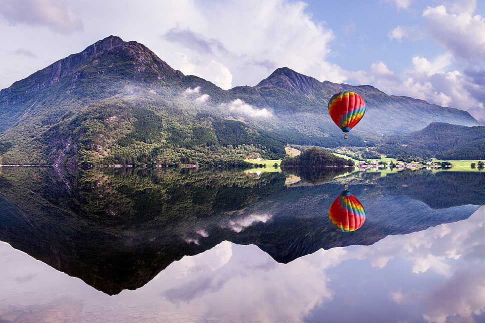 red and multicolored hot air balloon, lake, mountains HD wallpaper