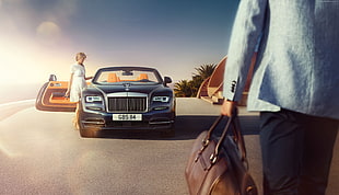 photography of woman standing near gray Rolls-Royce Wraith