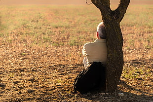 man sitting beside tree