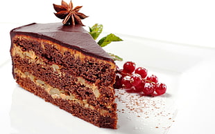 piece of chocolate cake beside cherries on top of plate