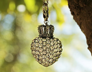 gold-colored clear gemstone crown pendant