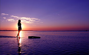 silhouette of female beside body of water