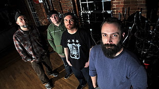 four men standing on brown wooden parquet floor