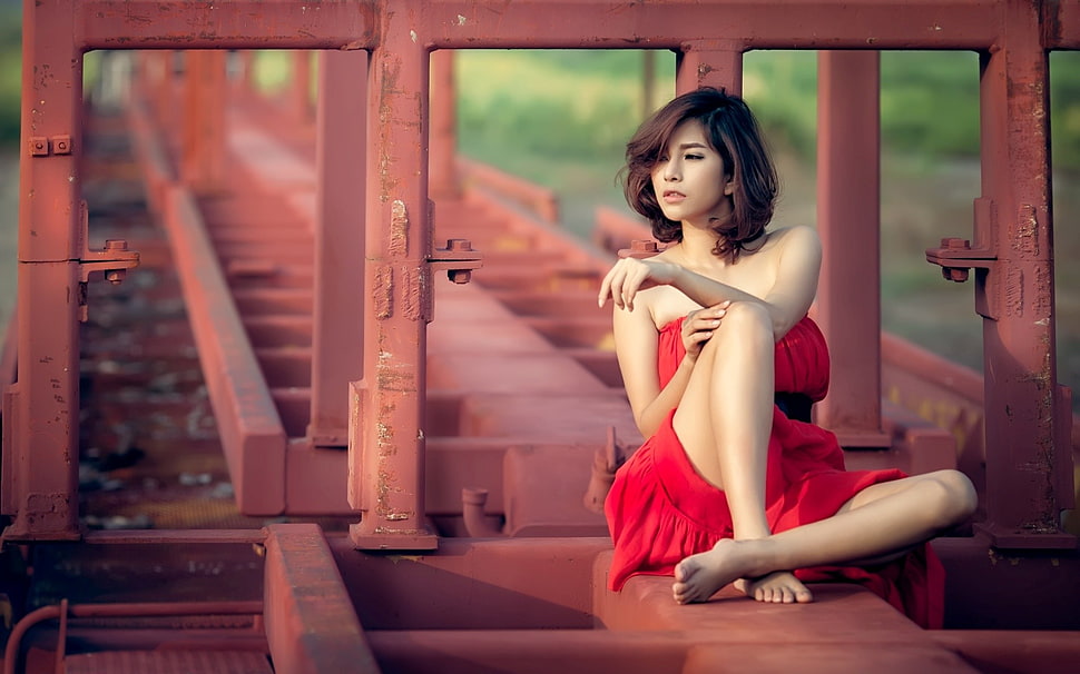 woman in red dress taking a photography on a red metal frames HD wallpaper