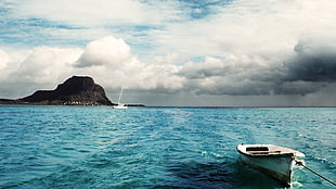 photography of white outboard boat on ocean