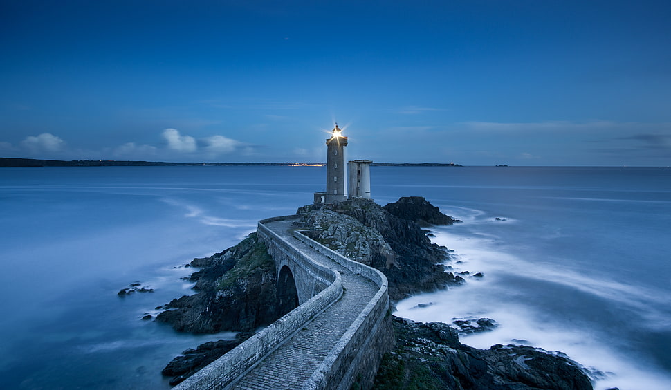 lighthouse on island under blue sky HD wallpaper